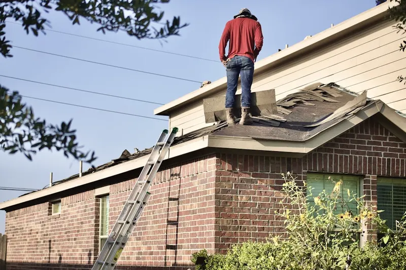 Professional roofer working on a residential roof in Bombay Woods